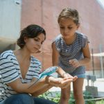 Femme et fille avec perruche ondulée pour page monde formation et academy animalière oiseaux